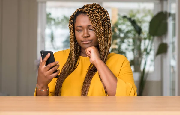 Afrikalı-Amerikalı kadın Smartphone ciddi bir yüz düşünme soru hakkında çok kullanarak fikir karışık