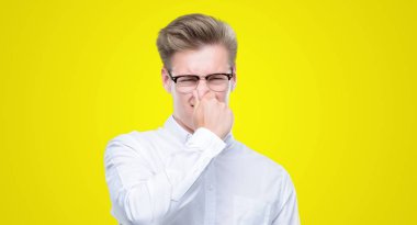 Genç yakışıklı sarışın adam bir şey pis ve iğrenç kokulu, dayanılmaz koku, umutla parmaklarıyla burnuna. Kötü kokuyor kavramı.