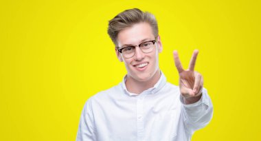 Gösterilen ve parmakları ile işaret genç yakışıklı sarışın adam ikincisi ise kendinden emin ve mutlu gülümseyerek.