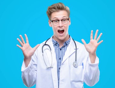 Genç yakışıklı sarışın doktor kocaman bir gülümseme ile çığlık ve ellerini kaldırdı çok mutlu ve heyecanlı, kazanan ifade kutluyor zafer