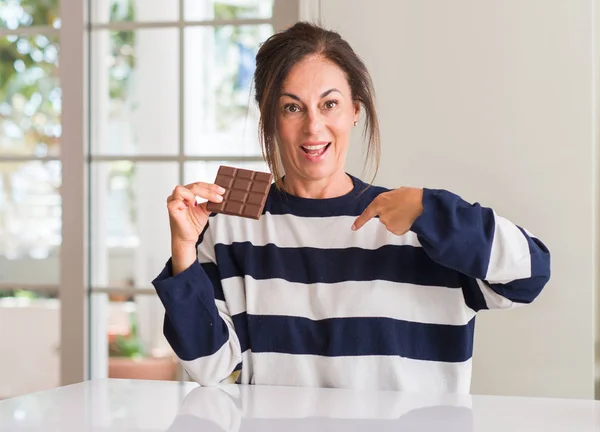 Středního Věku Žena Jíst Čokolády Překvapením Tváří Ukazuje Prstem Sebe — Stock fotografie