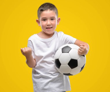 Duygu tezahürat gurur çığlık ve zafer ve başarı çok heyecanlı, kutluyor futbol topuyla oynayan koyu saçlı küçük çocuk