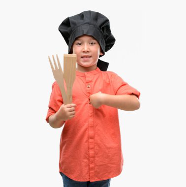 Koyu saçlı küçük çocuk şef üniforması sürpriz yüz işaret parmağı kendisine