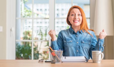 Kızıl saçlı kadın gurur çığlık ve zafer ve başarı çok kutluyor evde eğitim heyecanlı, duygu tezahürat