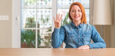 Kızıl saçlı kadın evde gösterilen ve parmak dördüncü gülümseyen ise kendinden emin ve mutlu yukarı dönük.