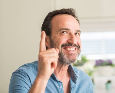 Yakışıklı ortadaki adam bir fikirle sürpriz yaş ya da gülen yüz, bir numara ile işaret parmağı soru