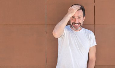 Üst düzey yakışıklı kafasına, el ile vurguladı duvarın üzerinden ayakta şok utanç ve sürpriz suratla, öfkeli ve sinirli. Korku ve hata için üzgün.