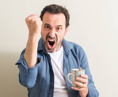 Komuta sizde rahatsız bir kupa kahve ve öfke, çılgın ve yükseltilmiş el, öfke kavramı ile diye bağıran ile sinirli bağırarak içme