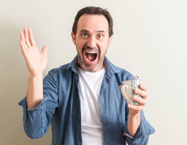 Komuta sizde büyük gülümseme ile çığlık zaferini kutluyor ve ellerini kaldırdı bir kupa çok mutlu ve heyecanlı, kazanan ifadesinde kahve içme