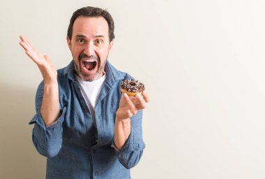 Komuta sizde çikolatalı çörek çok mutlu ve heyecanlı, kazanan ifade ile büyük çığlık zaferini kutluyor yeme gülümse ve el kaldırdı