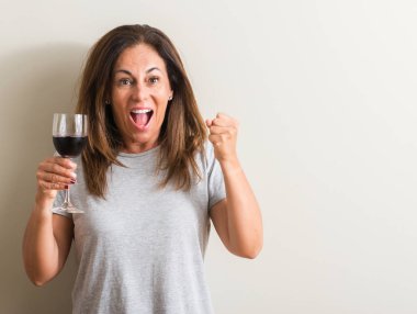 Duygu tezahürat gurur çığlık ve zafer ve başarı çok heyecanlı, kutluyor kadeh kırmızı şarap içme orta yaş kadın