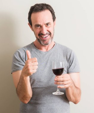 Komuta sizde ok işareti, başparmak ile parmak, mükemmel işareti yapıyor kocaman bir gülümseme ile mutlu bir bardak kırmızı şarap içme