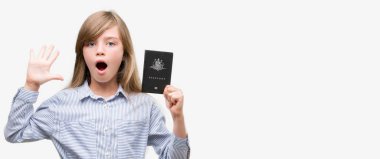 Genç Sarışın yürümeye başlayan çocuk büyük gülümseme ile çığlık zaferini kutluyor ve ellerini kaldırdı Avustralya pasaportu çok mutlu ve heyecanlı, kazanan ifade holding