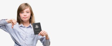 Başparmak aşağı, ret kavramı ile eksi işareti gösteren genç sarışın yürümeye başlayan çocuk holding Avustralya pasaportu kızgın yüzü ile sevmemek