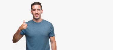 Hareketi el ile mutlu yaşasın yapan yakışıklı genç casual erkek. Kameraya bakarak başarı gösteren ile ifade onaylama.