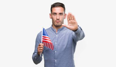 Yakışıklı genç adam bir bayrak ile Amerika holding açık el dur işareti ile ciddi ve kendine güvenen ifade, savunma hareketi yapıyor