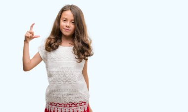 Esmer Latin kız gülümseyerek ve süre seyir ve kamera boyutu işaret parmaklarıyla yapıyor el ile kendine güvenen el hareketi. Ölçü kavramı.