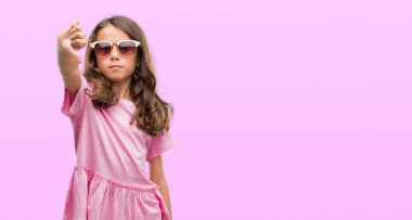 Kızgın yüz, eksi işareti aşağı antipati başparmak ile gösterilen, ret kavramı ile güneş gözlüğü takıyor esmer Latin kız