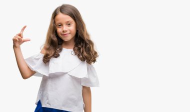 Esmer Latin kız gülümseyerek ve süre seyir ve kamera boyutu işaret parmaklarıyla yapıyor el ile kendine güvenen el hareketi. Ölçü kavramı.