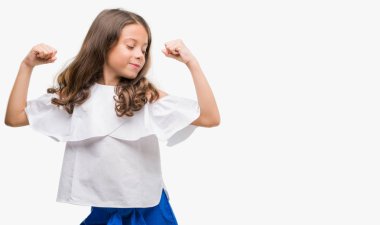 Esmer Latin kız gururlu gülümseyen kol kasları gösterilen. Fitness kavramı.