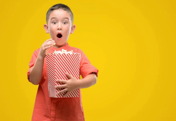 Dunkelhaariges Kleines Kind Das Popcorn Isst Erschrocken Mit Einem Überraschungsgesicht — Stockfoto