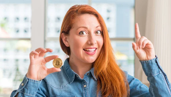 Mulher Ruiva Segurando Criptomoeda Bitcoin Casa Surpreso Com Uma Ideia — Fotografia de Stock