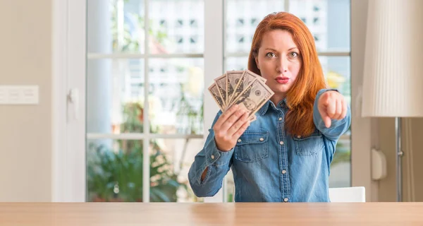 Roodharige Vrouw Bedrijf Dollar Biljetten Thuis Met Vinger Wijzen Naar — Stockfoto