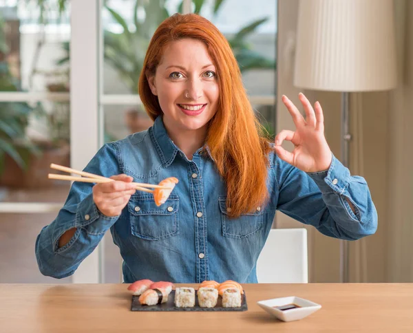 Mulher Ruiva Comendo Sushi Usando Pauzinhos Fazendo Sinal Com Dedos — Fotografia de Stock