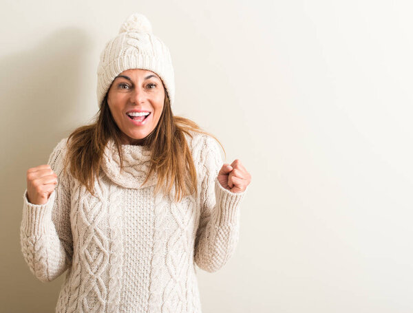 Middle age woman wearing wool winter cap screaming proud and celebrating victory and success very excited, cheering emotion