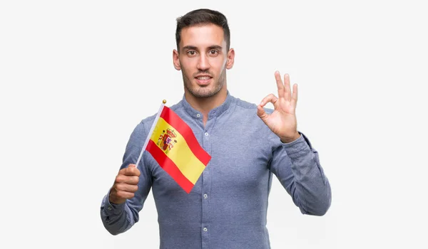 優秀なシンボルの指で サインをしているスペインの旗を保持しているハンサムな若い男 — ストック写真