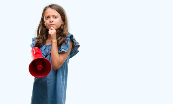 Morena Hispânico Menina Segurando Vermelho Megafone Sério Rosto Pensando Sobre — Fotografia de Stock