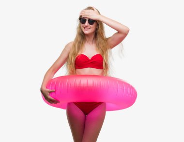 Sarışın genç kadın giyen bikini ve kafasına, utanç ve sürpriz ile şok el ile vurguladı holding pembe flatör yüz, öfkeli ve sinirli. Korku ve hata için üzgün.