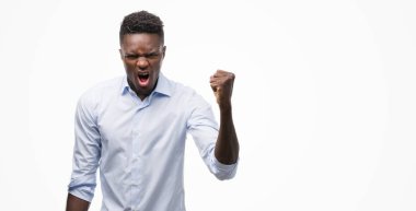 Afrikalı Amerikalı genç adam rahatsız bir gömlek giymiş ve öfke, deli ile sinirli bağırarak ve yükseltilmiş el ile bağırmaya kavramı öfke