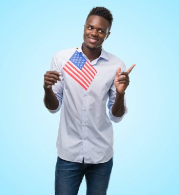 ABD bayrağı çok mutlu el ve parmak ile tarafına işaret tutan genç Afro-Amerikan adam