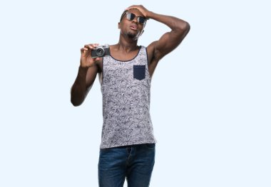 Vintage kamerayı kafasına, el ile vurguladı genç Afro-Amerikan adam şok utanç ve sürpriz suratla, öfkeli ve sinirli. Korku ve hata için üzgün.