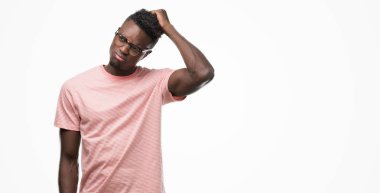 Pembe t-shirt giyen genç Afro-Amerikan adam yanıltır ve soru hakkında merak ediyorum. Şüphe, kafasına el ile düşünme ile belirsiz. Dalgın kavramı.