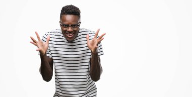 Gözlük ve deniz kuvvetleri giyen genç Afro-Amerikan adam deli ve silah ile başarı için hayran kutluyor t-shirt kaldırdı ve açık gözleri çığlık heyecanlı. Kazanan kavramı