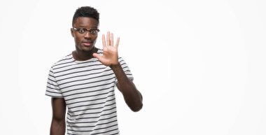 Gözlük ve gösterilen ve parmakları ile işaret lacivert t-shirt giyen genç Afro-Amerikan adam kendinden emin ve mutlu gülümseyerek süre beş numara.