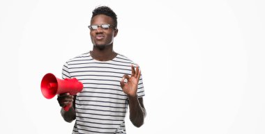 Parmak, mükemmel sembolü ile ok işareti yapıyor megafon tutan genç Afro-Amerikan adam