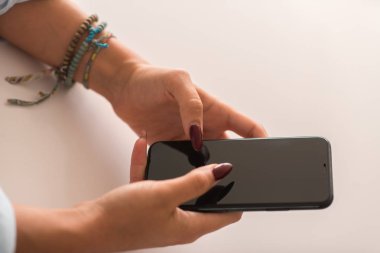 Evde akıllı telefon kullanan bir kadın.