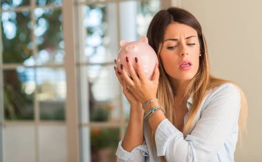 Güzel ve genç birbayan kumbara evde ne kadar para var merak. İş kavramı.