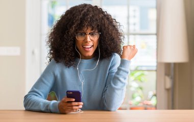 Duygu tezahürat gurur çığlık ve zafer ve başarı çok heyecanlı, kutluyor smartphone kullanan güzel Afrikalı-Amerikalı kadın