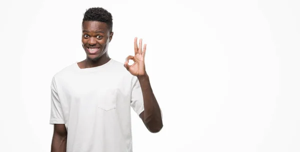 若いアフリカ系アメリカ人の手と指で サインをしている肯定的な笑みを浮かべて白い シャツを身に着けています 成功した式 — ストック写真