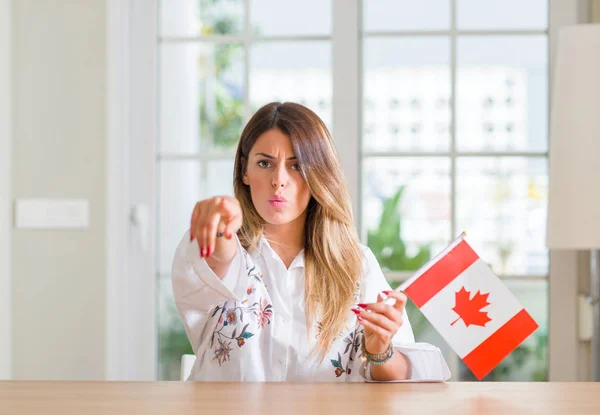 Νεαρή Γυναίκα Στο Σπίτι Κρατώντας Σημαία Του Καναδά Δείχνει Δάχτυλο — Φωτογραφία Αρχείου