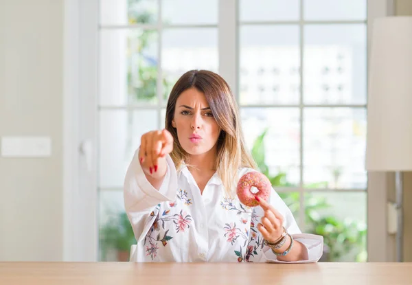 Giovane Donna Casa Mangiare Una Ciambella Che Punta Con Dito — Foto Stock