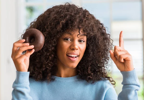 Fiatal Afrikai Amerikai Otthon Tartja Csokoládés Fánk Meglepett Mutatóujjal Egy — Stock Fotó