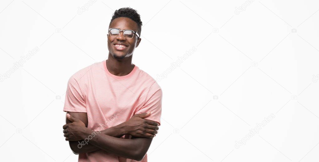 Young african american man wearing pink t-shirt happy face smiling with crossed arms looking at the camera. Positive person.