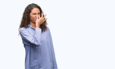 Bir şey pis ve iğrenç kokulu genç İspanyol iş kadını, dayanılmaz koku, umutla parmaklarıyla burnuna. Kötü kokuyor kavramı.