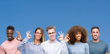 Üzerinde mavi blackground gülümseyerek el ve parmaklar ok işaretiyle yapıyor olumlu arkadaş grubu bileşimi. Başarılı ifade.