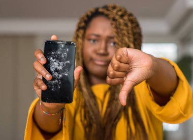 Afrikalı-Amerikalı kadın kırık smartphone kızgın yüzü, eksi işareti aşağı antipati başparmak ile gösterilen, ret kavramı ile gösterilen